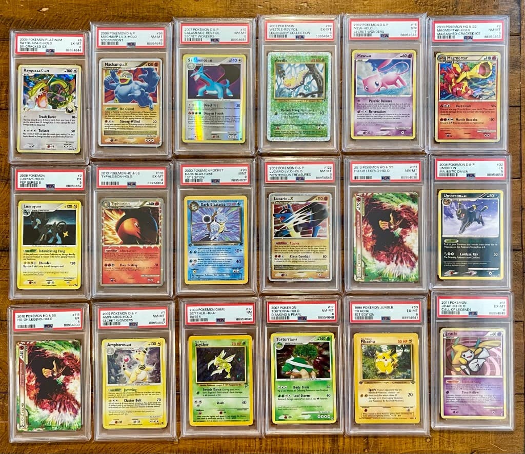 A wide grid of PSA-graded Pokémon slabs on a wooden desk for cert verification and per-slab comp review.